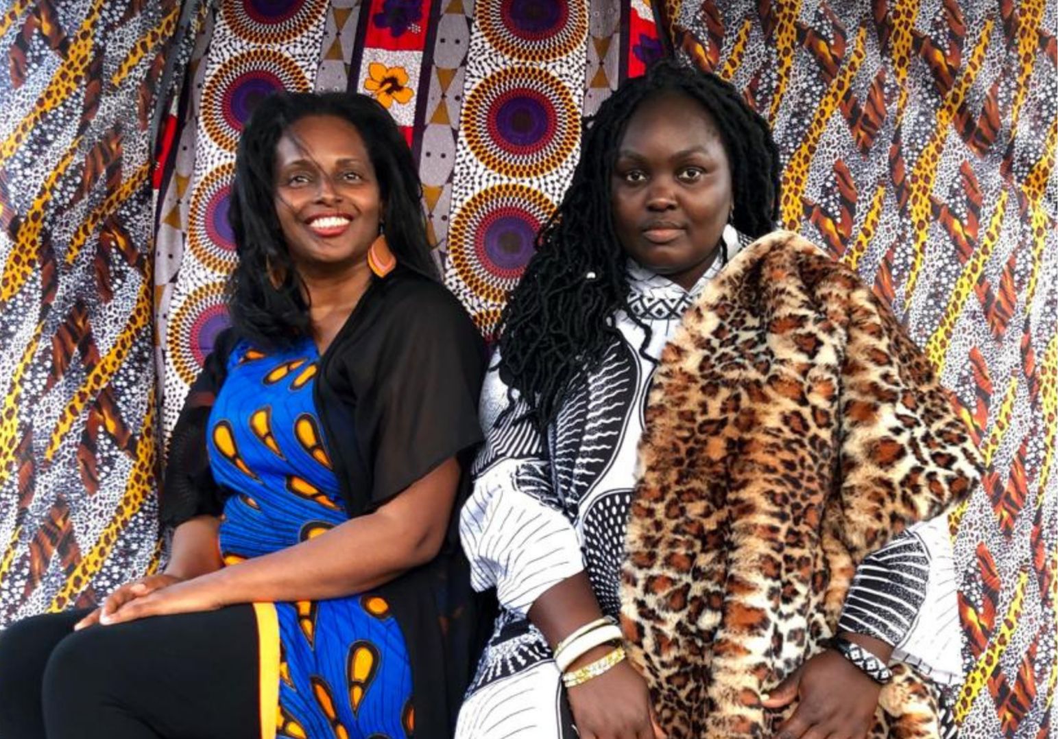 Two women in colorful outfits posing for a picture.