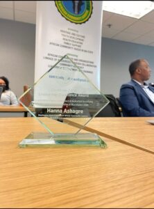 A glass award sitting on top of a wooden table.