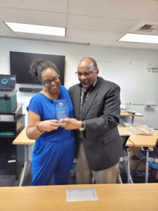 A man and woman holding up a cell phone.