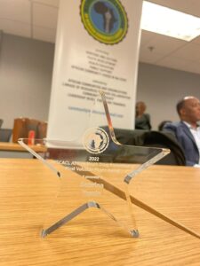 A glass award sitting on top of a wooden table.