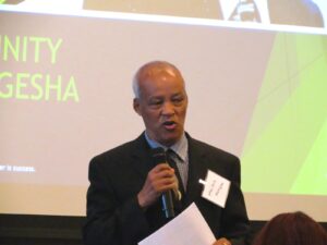 A man in suit and tie holding a microphone.