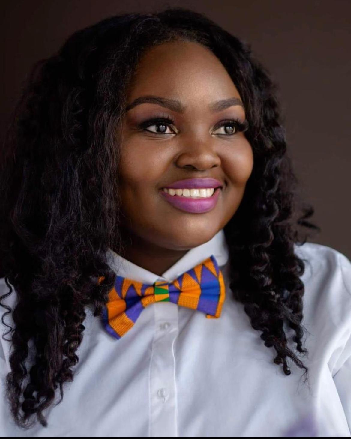 A woman with long hair wearing an orange bow tie.