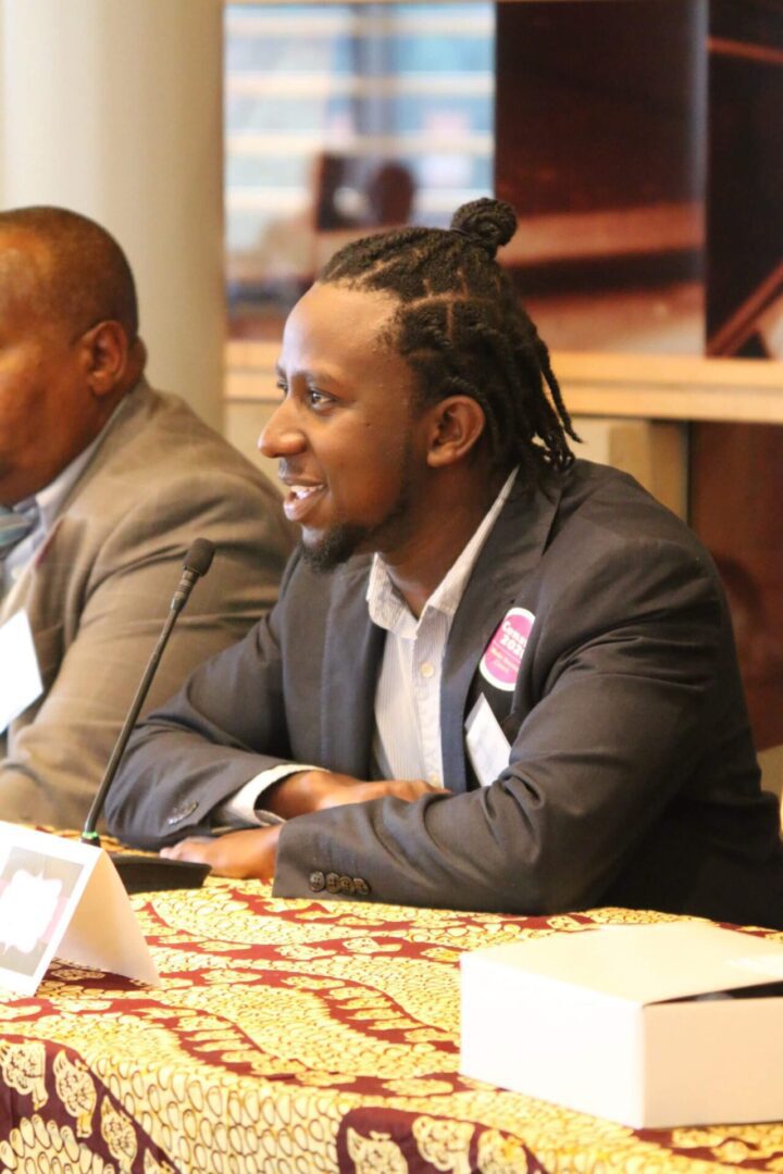 A man with long hair sitting at a table.