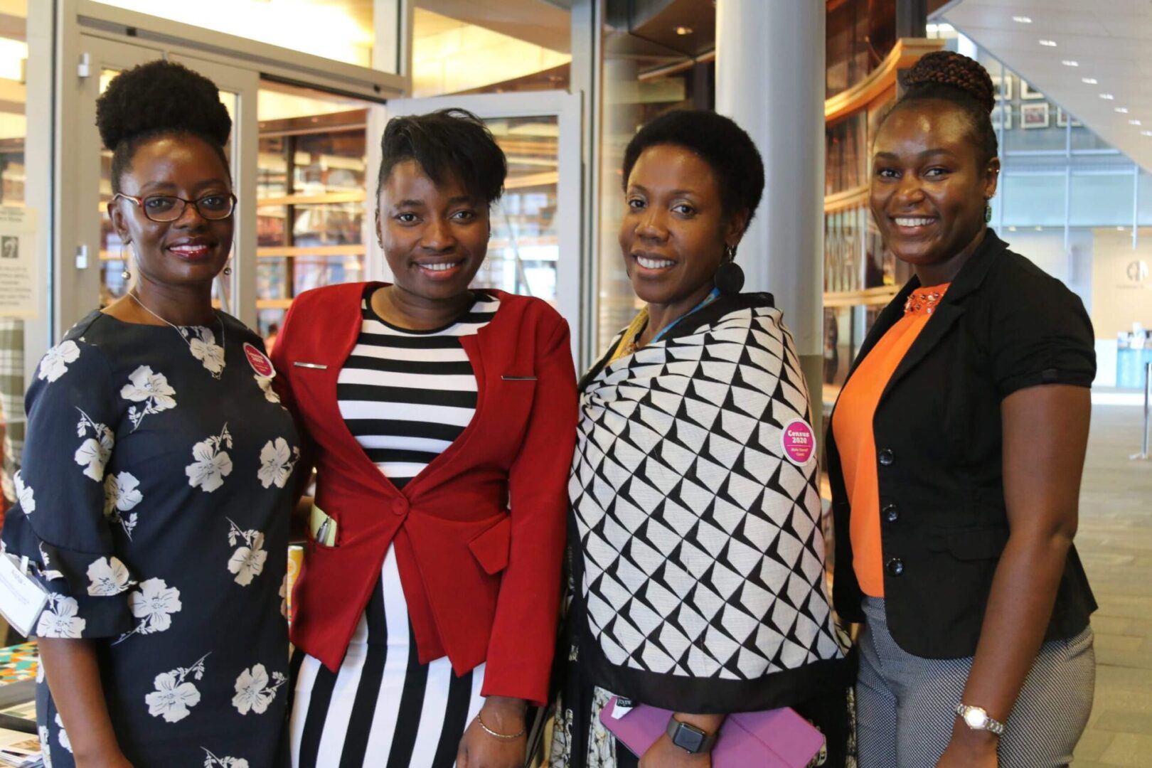 Four women standing next to each other in a row.